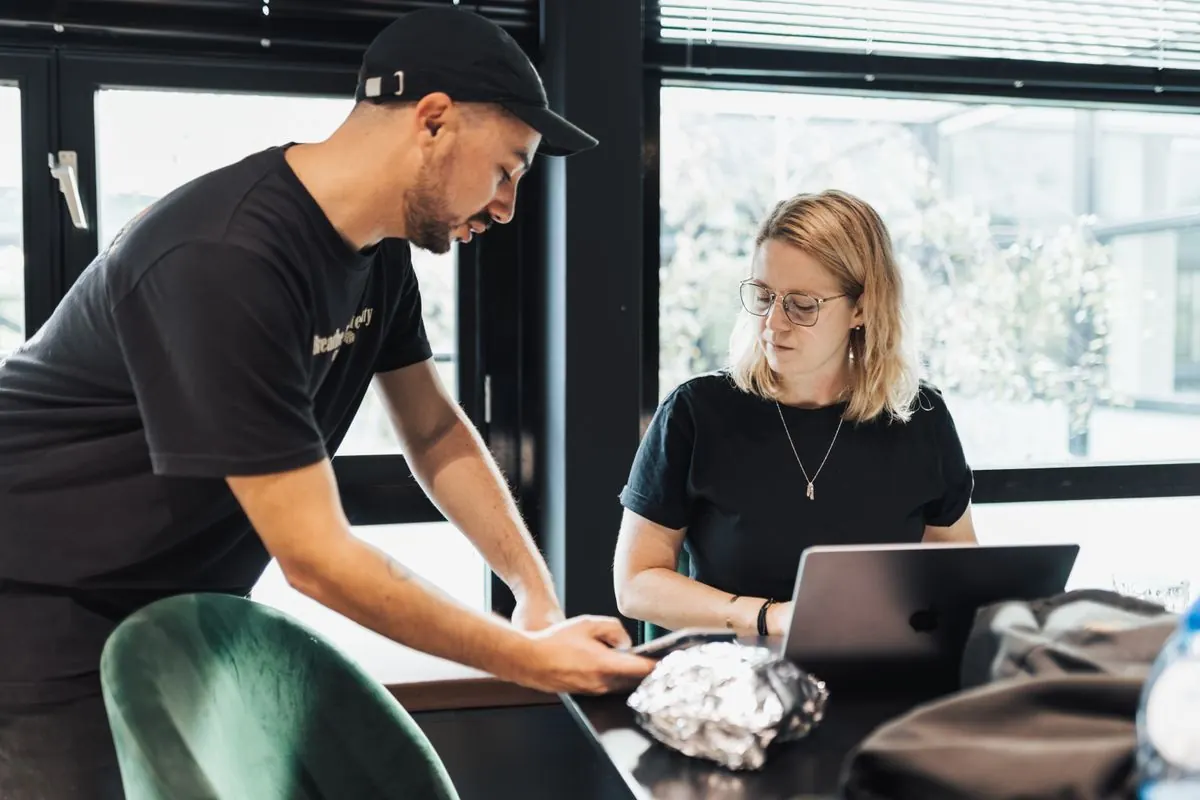 Colegas de trabalho discutindo um projeto com notebook em um escritório moderno